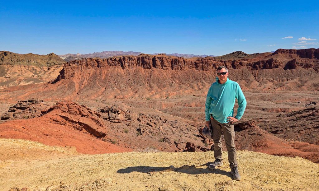 Man standing in front of rock formations.